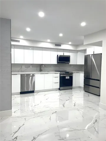 a kitchen with stainless steel appliances granite countertop a refrigerator and a stove top oven