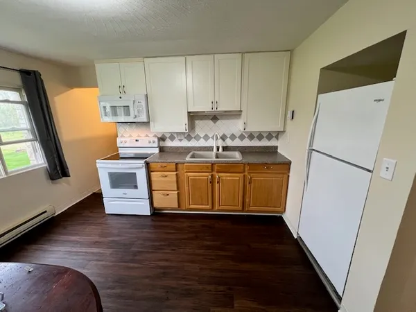 a kitchen with wooden cabinets sink and refrigerator