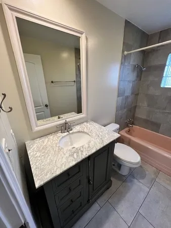 a bathroom with a granite countertop sink toilet and shower