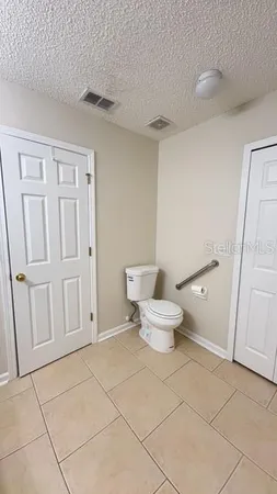 a white toilet sitting next to a bathroom sink and a mirror
