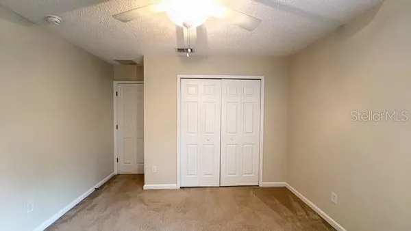 an empty room with chandelier fan