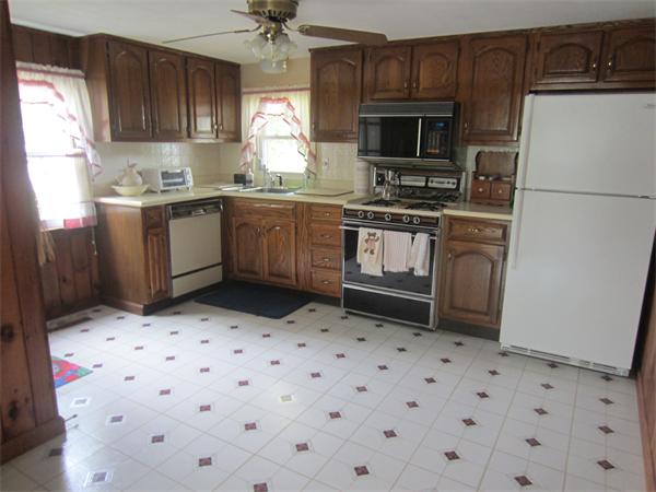 22 Agawam Beach Road Wareham, MA 02571 - Photo 6 of 16 a kitchen with granite countertop a sink a stove a microwave a refrigerator a counter top space and cabinets