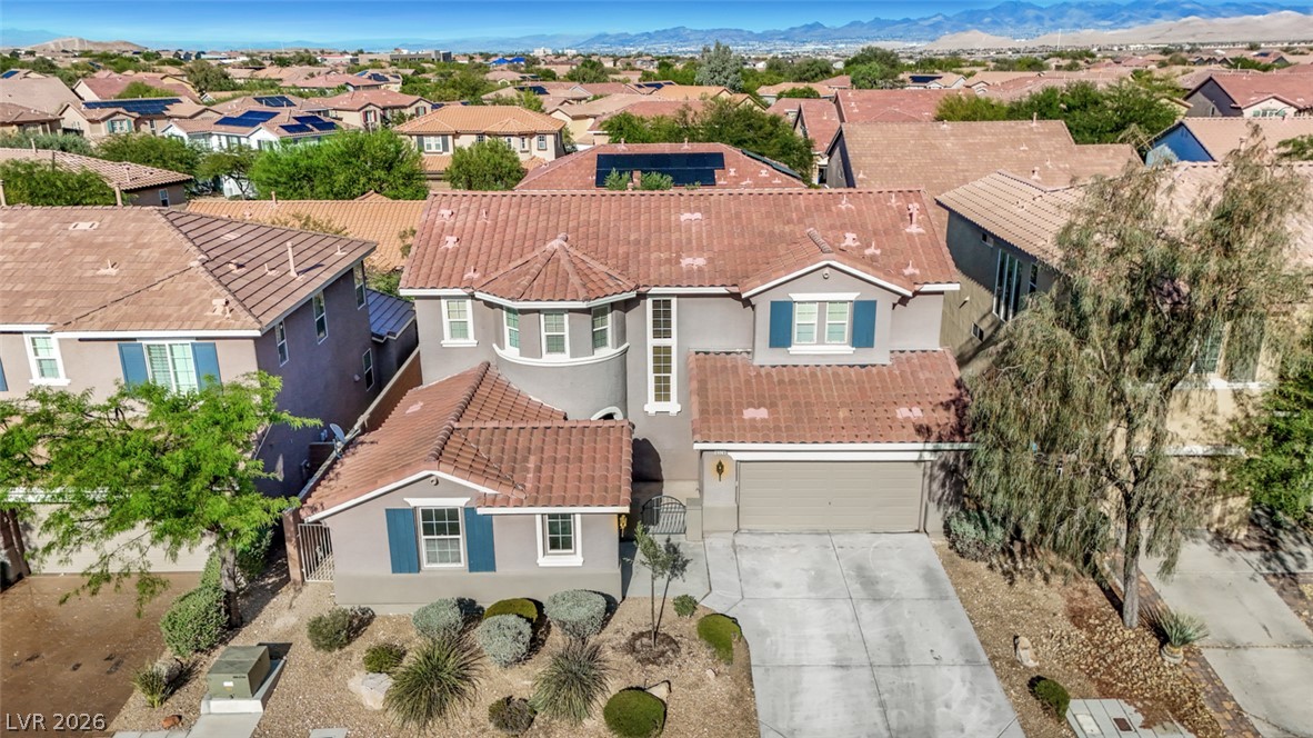 10328 Hawk Ravine Street Las Vegas, NV 89178 - Photo 54 of 55 An aerial perspective reveals a residential community with tile roofs, desert landscaping, and distant mountains.