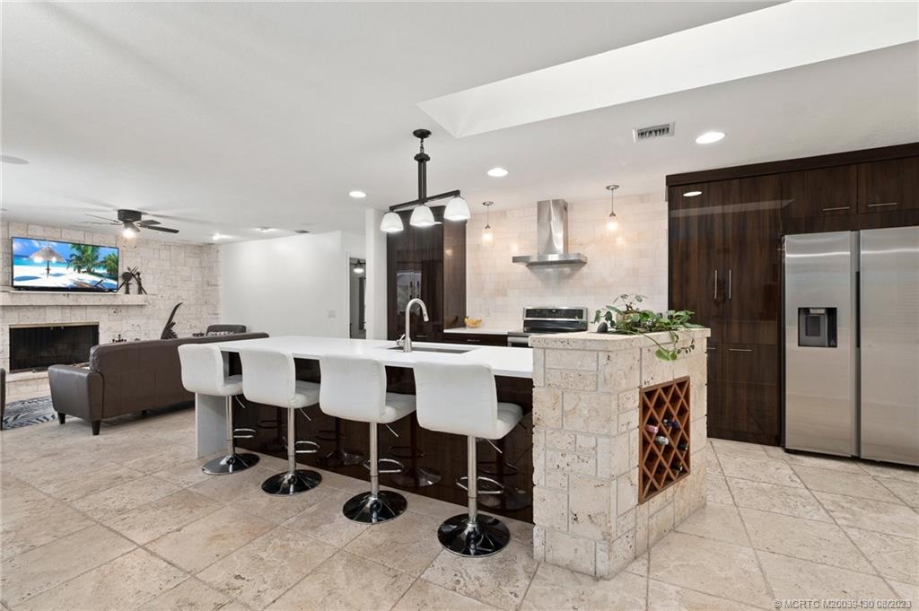 40 North River Road Stuart, FL 34996 - Photo 12 of 51 a kitchen with a dining table chairs refrigerator and microwave