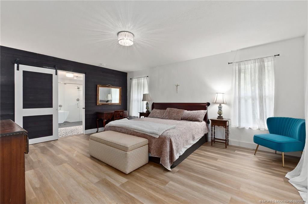 40 North River Road Stuart, FL 34996 - Photo 23 of 51 a spacious bedroom with a bed a couch and dresser