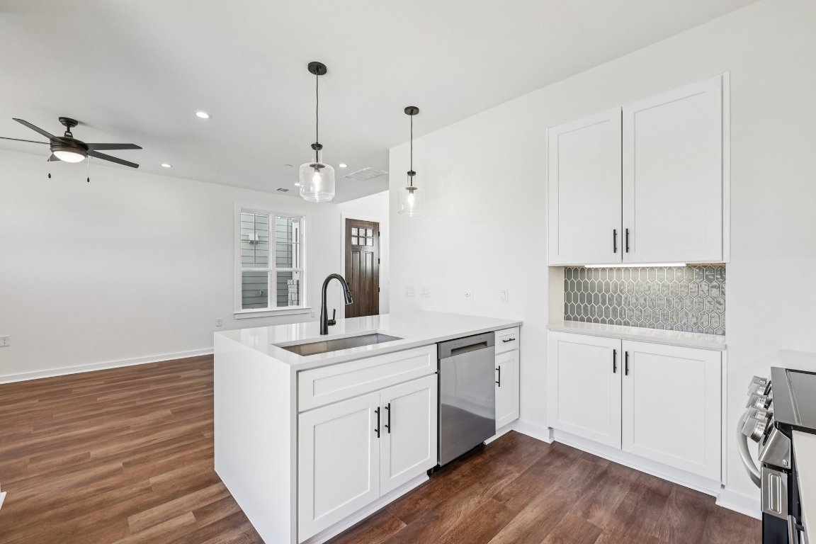 2414 Drew Lane, Unit 3 Austin, TX 78748 - Photo 13 of 38 a kitchen with a sink dishwasher and white cabinets with wooden floor