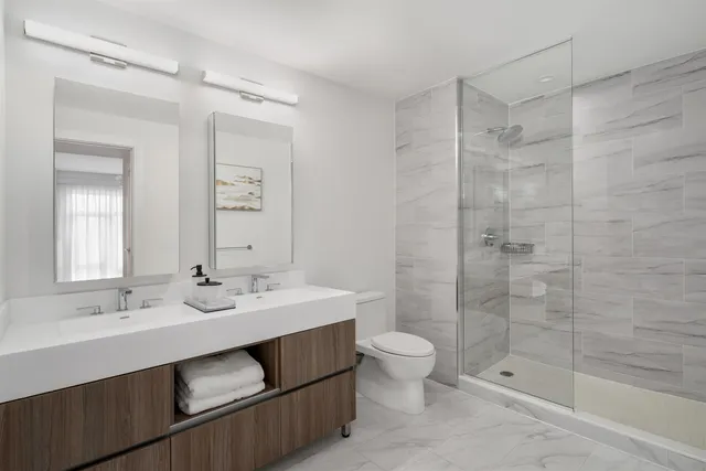a bathroom with a double vanity sink toilet and shower