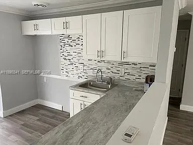 a view of a kitchen with sink and wooden floor