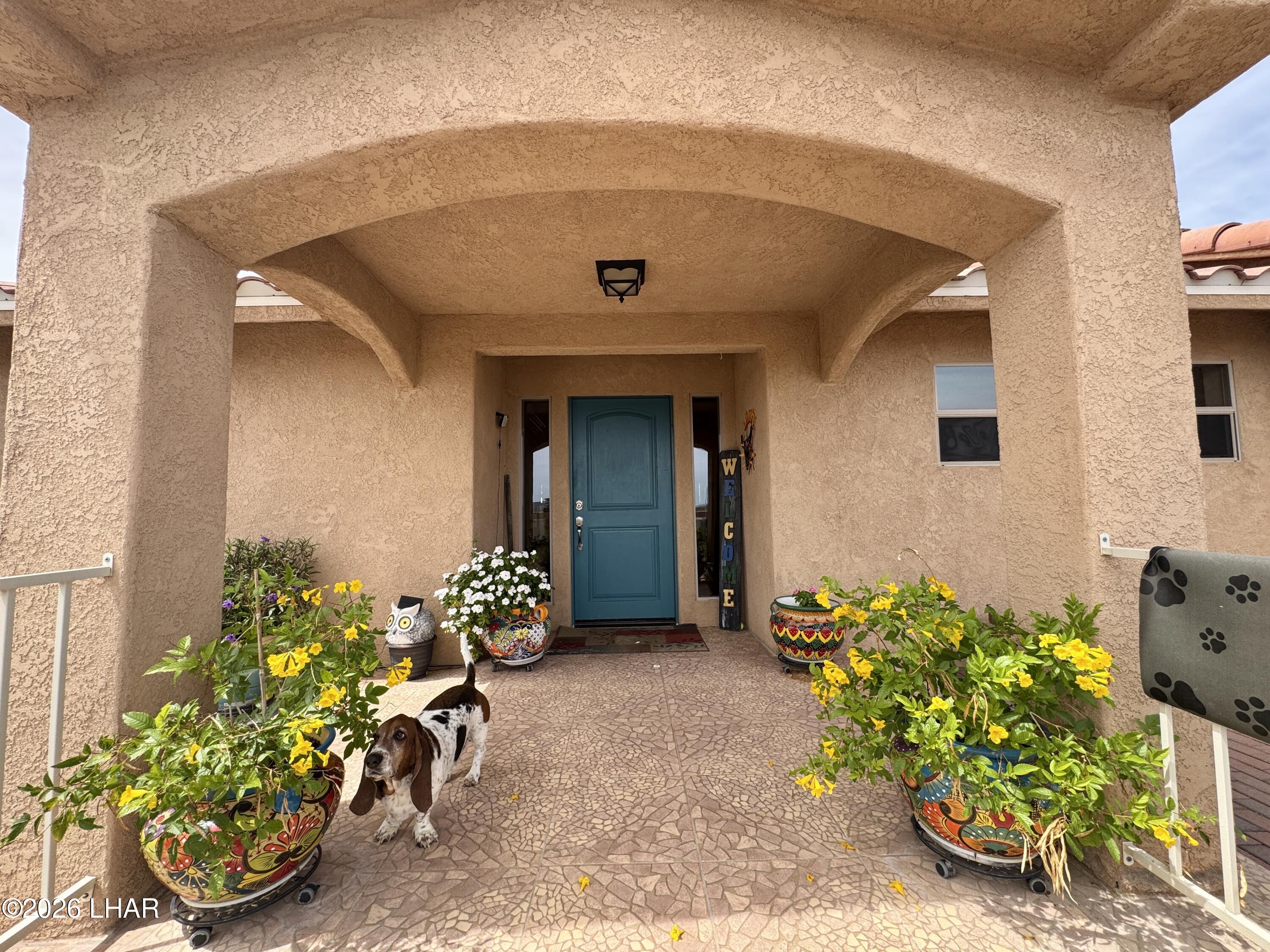 42832 La Posa Road Bouse, AZ 85325 - Photo 3 of 62 a front view of a house with lots of flowers in it