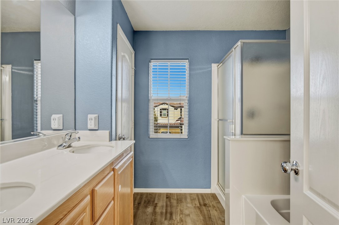 11159 Ranch Valley Street Las Vegas, NV 89179 - Photo 17 of 27 Double vanity and a modern shower enclosure create a functional, well-appointed bathroom space.