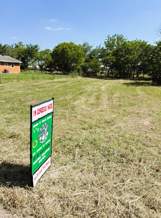 104 Burton Street Manor, TX 78653 - Photo 11 of 11 a sign that is sitting on the side of a lake