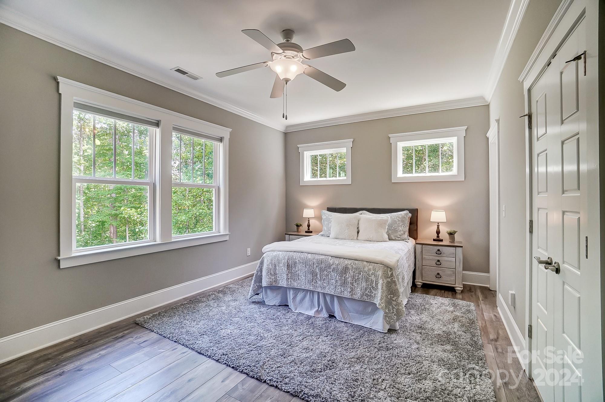 1123 Blacksnake Road Stanley, NC 28164 - Photo 31 of 48 a spacious bedroom with a large bed and a chandelier