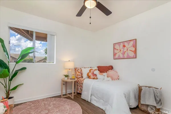 a bedroom with a bed and a potted plant on the dresser