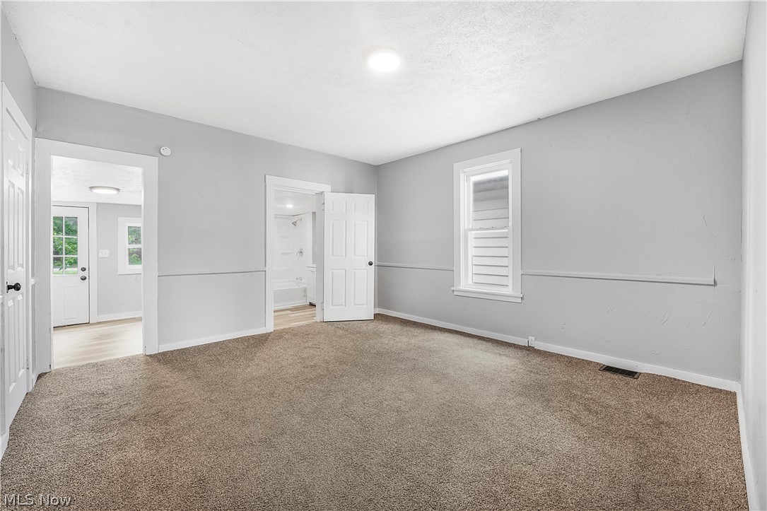 885 Wales Road Northeast Massillon, OH 44646 - Photo 26 of 34 Spacious room featuring neutral carpeting, light gray wall paint, and white trim