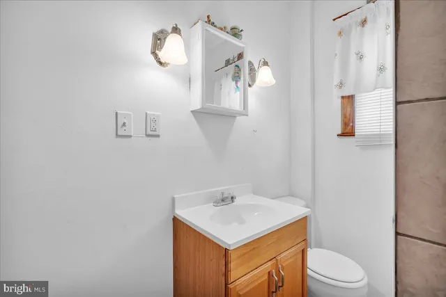 a bathroom with a sink a toilet and mirror