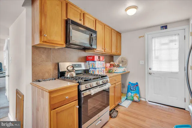 a kitchen with stainless steel appliances granite countertop a stove a sink dishwasher and a microwave with wooden floor