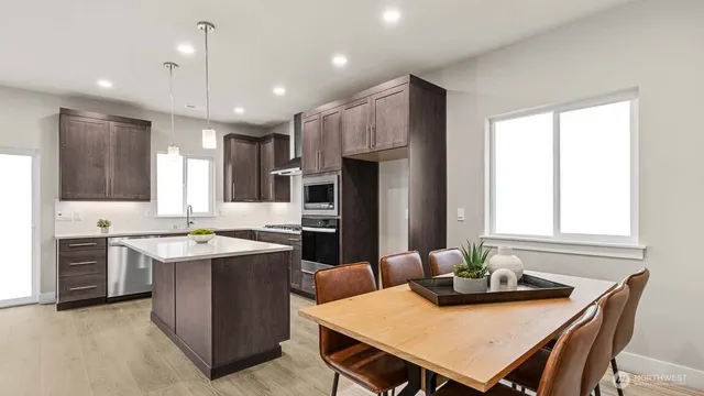 a kitchen with kitchen island a sink appliances and cabinets