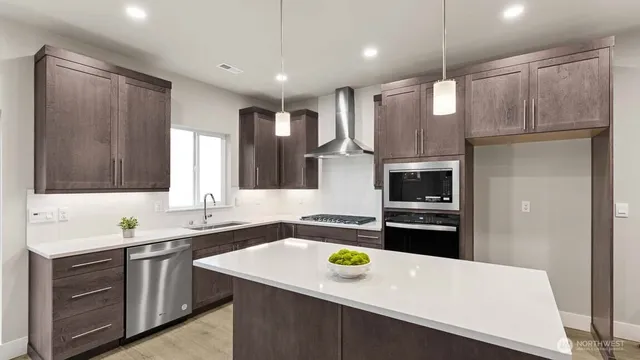 a kitchen with stainless steel appliances a sink stove and refrigerator