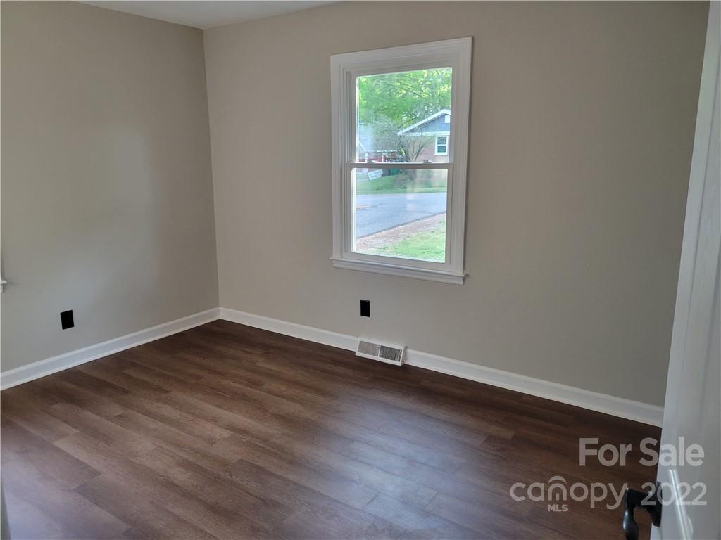 943 Tilden Road Charlotte, NC 28214 - Photo 11 of 14 an empty room with wooden floor and windows