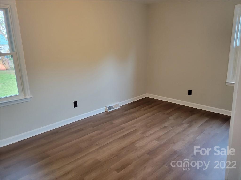 943 Tilden Road Charlotte, NC 28214 - Photo 12 of 14 an empty room with wooden floor and windows