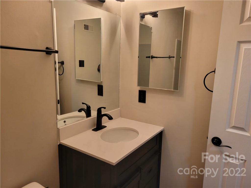 943 Tilden Road Charlotte, NC 28214 - Photo 14 of 14 a bathroom with a sink a mirror and shower