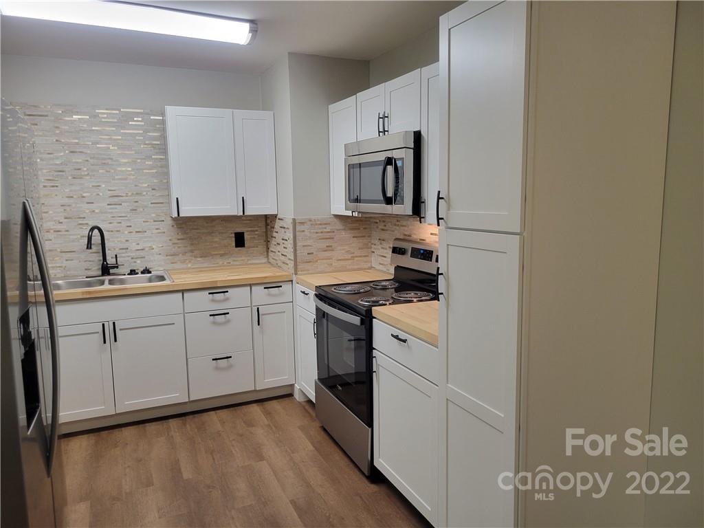 943 Tilden Road Charlotte, NC 28214 - Photo 3 of 14 a kitchen with cabinets stainless steel appliances and sink