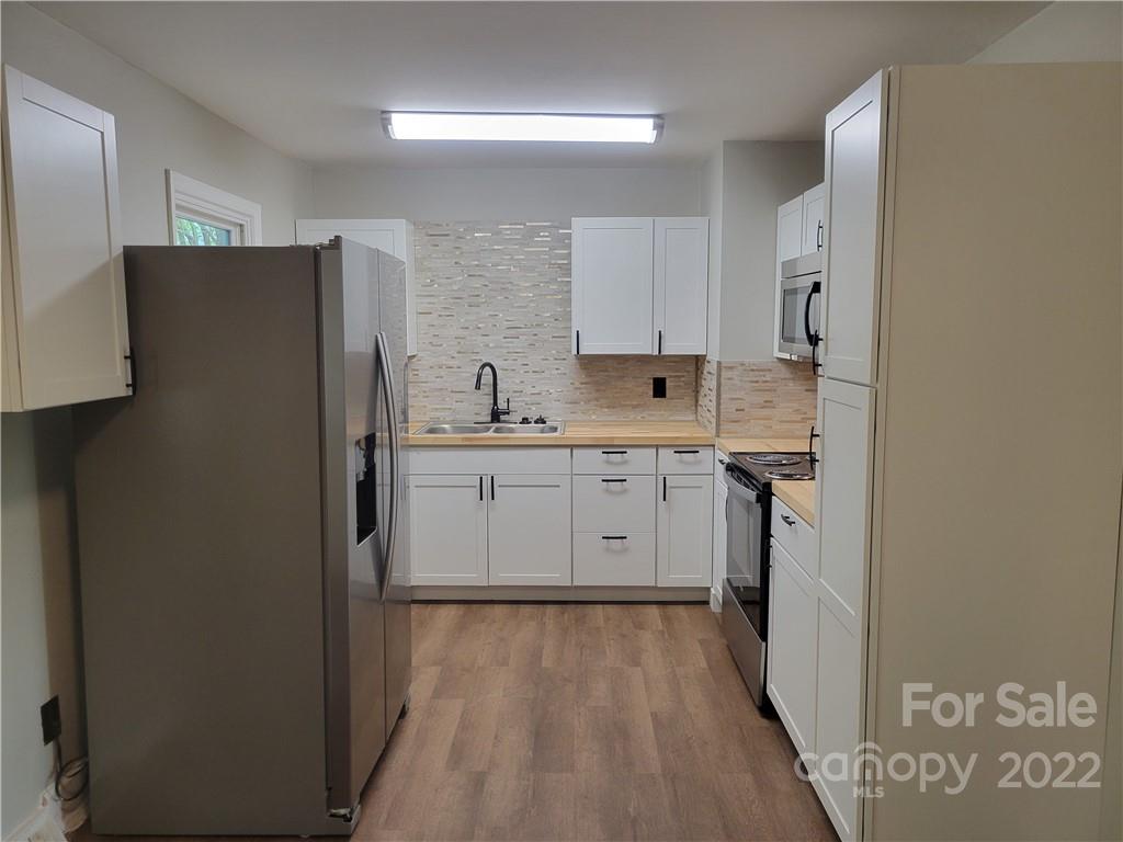 943 Tilden Road Charlotte, NC 28214 - Photo 5 of 14 a kitchen with a sink a refrigerator and cabinets