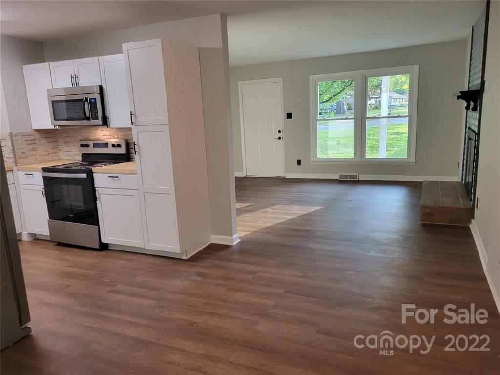 943 Tilden Road Charlotte, NC 28214 - Photo 7 of 14 a kitchen with kitchen island granite countertop a stove a sink and a microwave