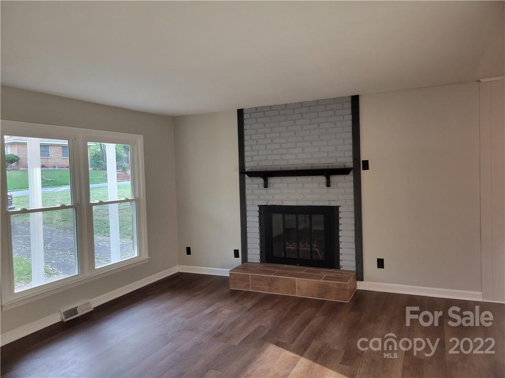 943 Tilden Road Charlotte, NC 28214 - Photo 9 of 14 a view of an empty room with wooden floor fireplace and a window