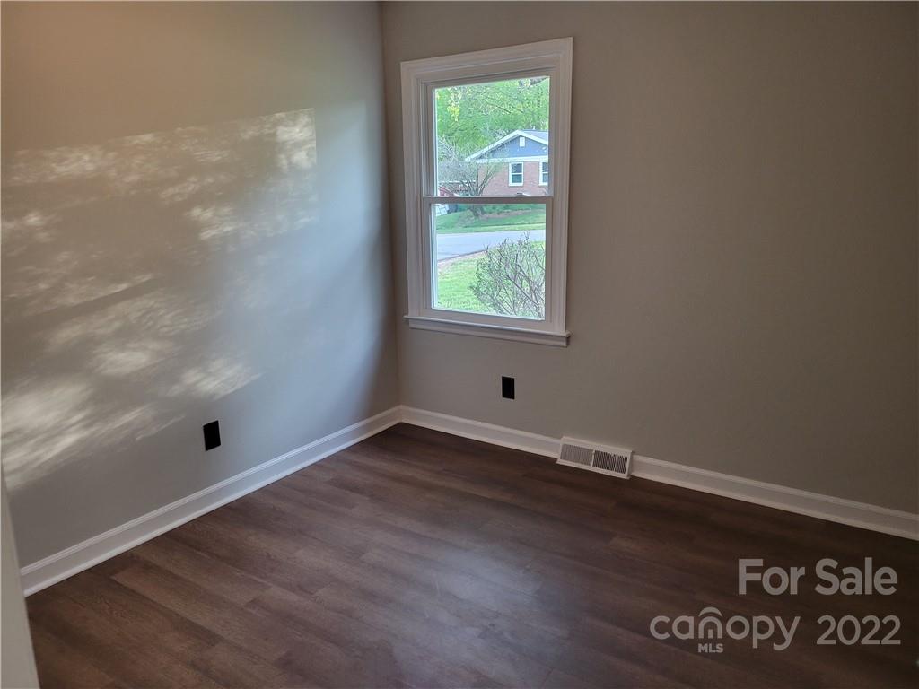 943 Tilden Road Charlotte, NC 28214 - Photo 10 of 14 an empty room with wooden floor and windows