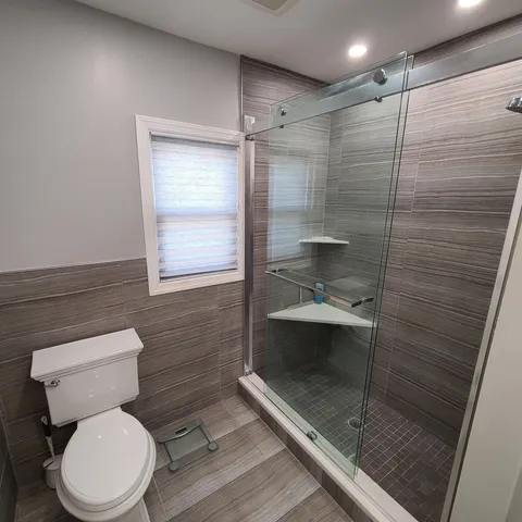 a bathroom with a toilet and a shower