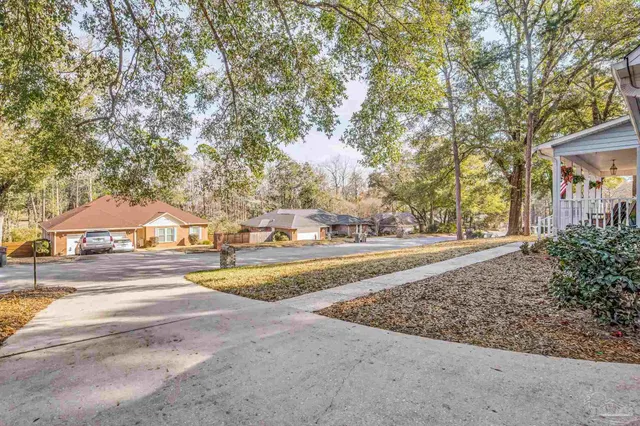 a view of a house with yard and chairs in patio