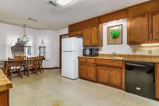 a kitchen with refrigerator cabinets and a sink