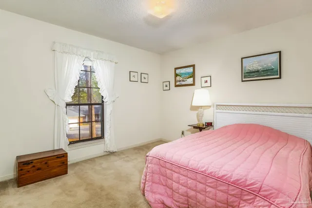 a view of a room with lots of furniture and a large window