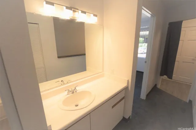 a bathroom with a granite countertop sink and a mirror