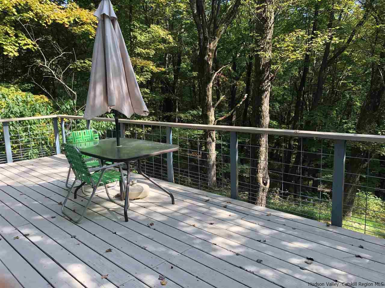 3674 Atwood Road Stone Ridge, NY 12484 - Photo 8 of 28 a view of a deck with chair and wooden floor
