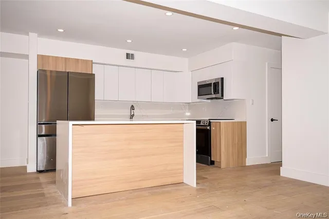 a kitchen with stainless steel appliances granite countertop a refrigerator and a stove