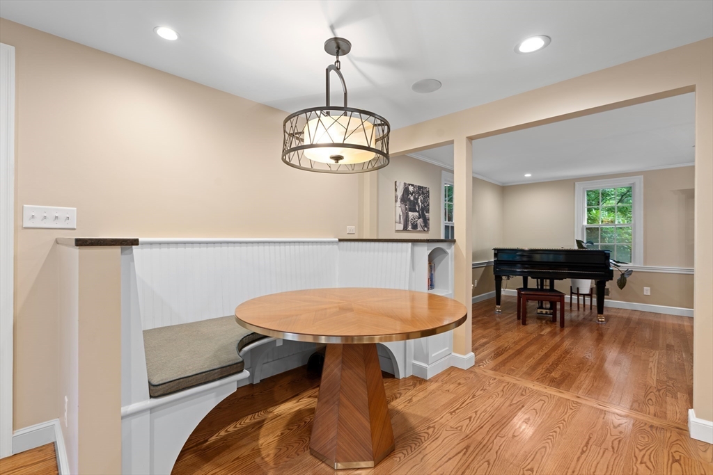 50 3 Ponds Road Wayland, MA 01778 - Photo 13 of 32 a dining room with wooden floor a chandelier a wooden table and chairs