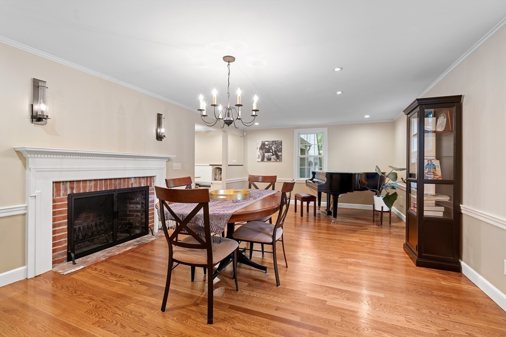 50 3 Ponds Road Wayland, MA 01778 - Photo 14 of 32 a dining room with furniture a fireplace and wooden floor