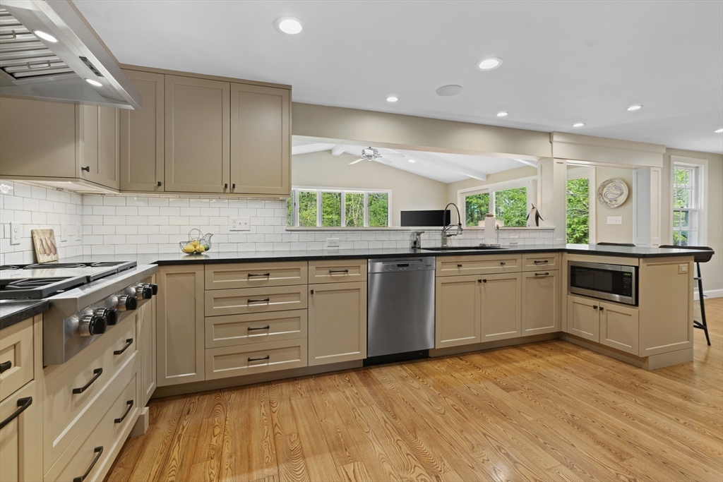 50 3 Ponds Road Wayland, MA 01778 - Photo 6 of 32 a kitchen with stainless steel appliances granite countertop white cabinets sink and window