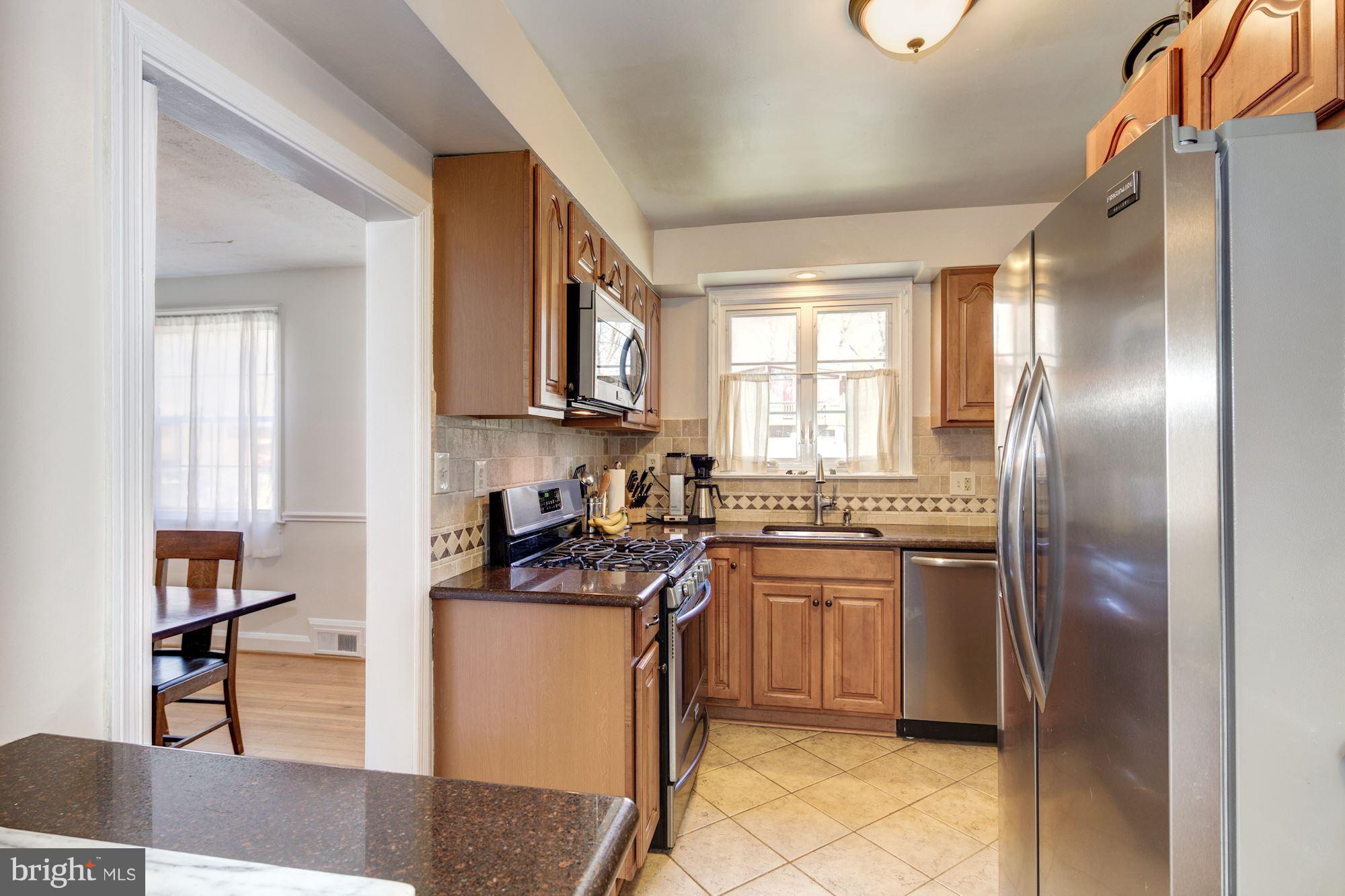 6722 Sherwood Road Baltimore, MD 21239 - Photo 11 of 30 a kitchen with stainless steel appliances granite countertop a stove a sink and a refrigerator