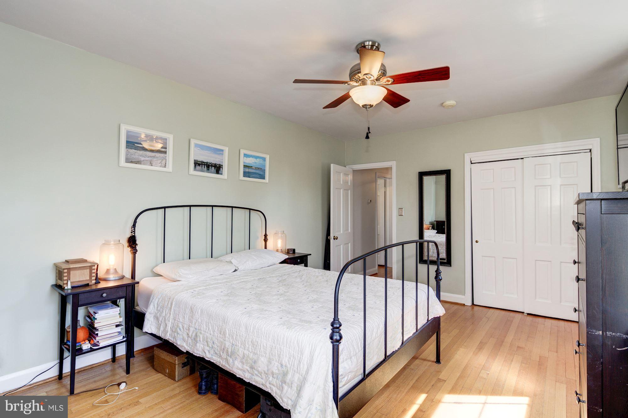 6722 Sherwood Road Baltimore, MD 21239 - Photo 18 of 30 a bedroom with a large bed and a chandelier