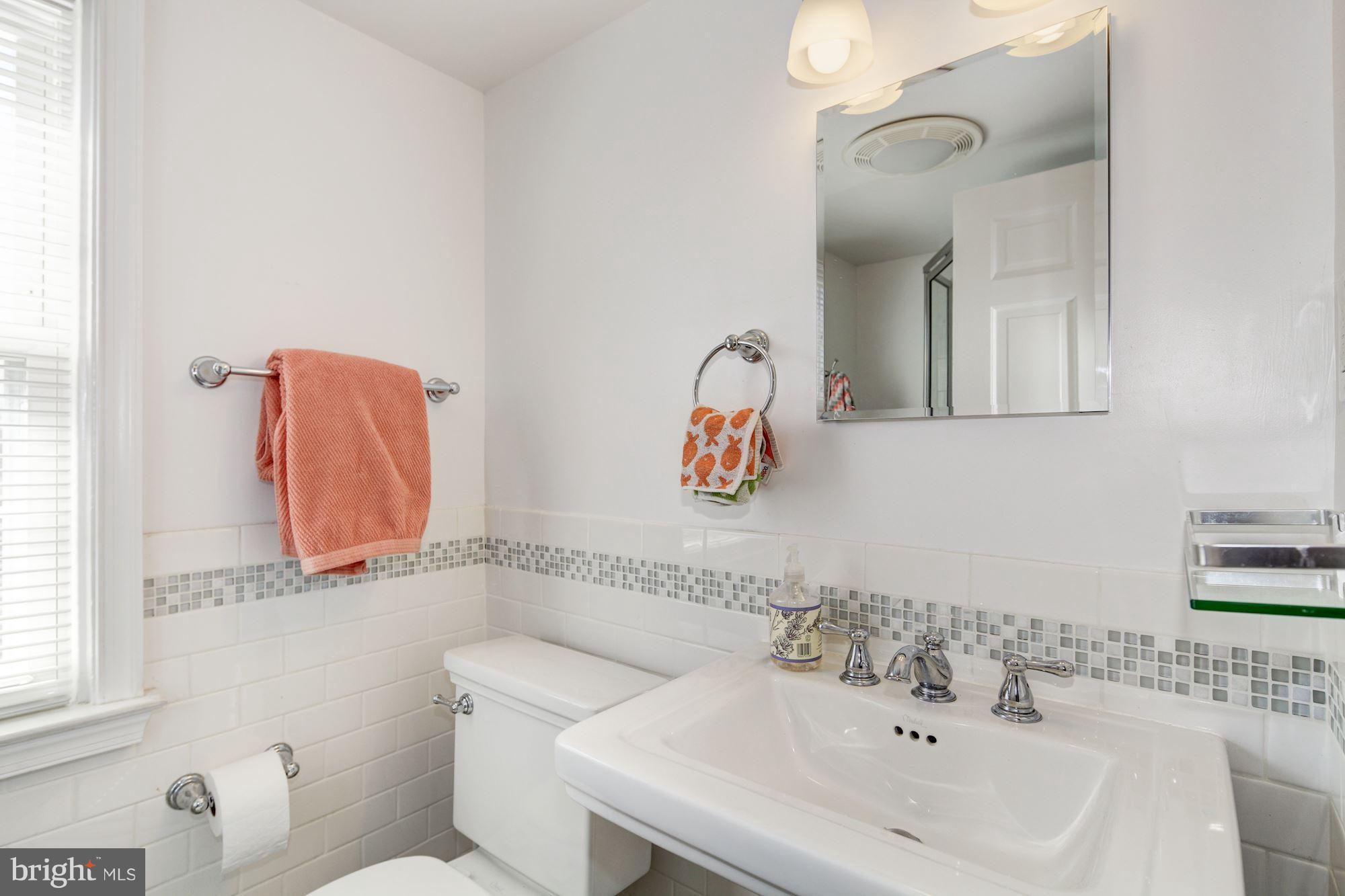 6722 Sherwood Road Baltimore, MD 21239 - Photo 22 of 30 a bathroom with a sink mirror and toilet