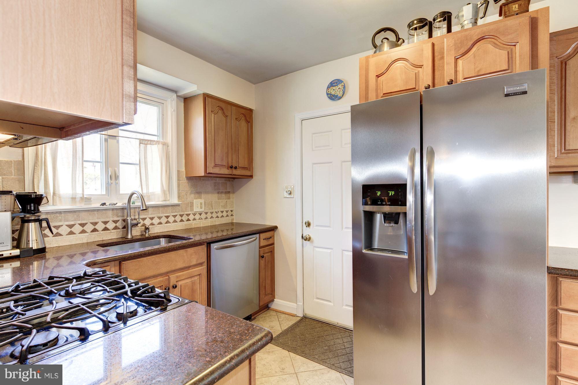 6722 Sherwood Road Baltimore, MD 21239 - Photo 9 of 30 a kitchen with stainless steel appliances granite countertop a sink stove and refrigerator