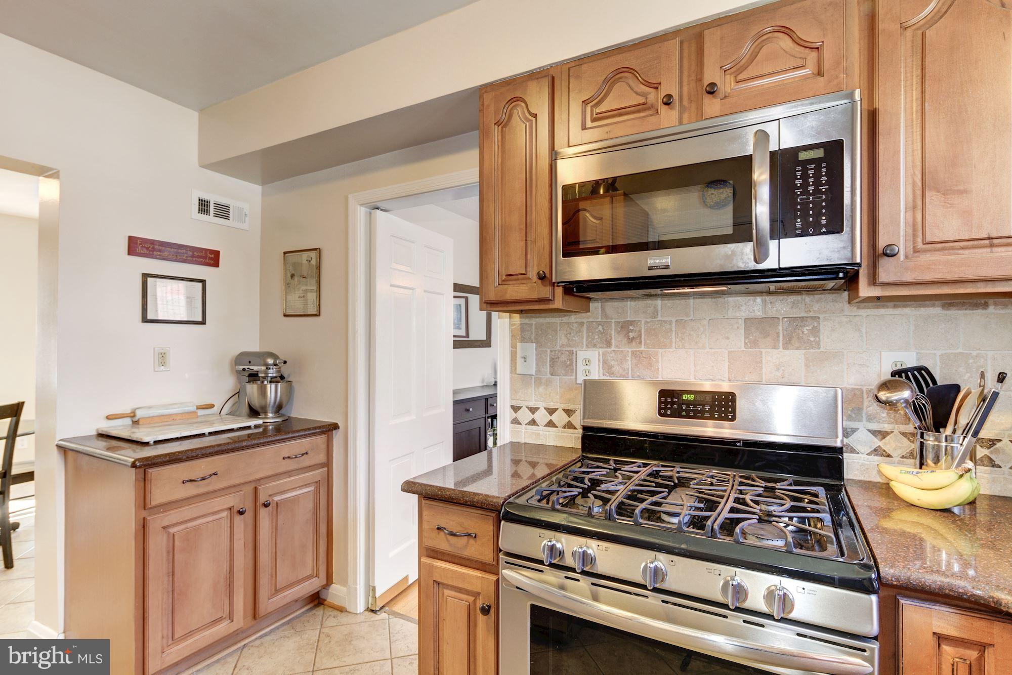 6722 Sherwood Road Baltimore, MD 21239 - Photo 10 of 30 a kitchen with granite countertop a stove top oven microwave and cabinets
