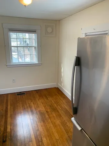 an empty room with wooden floor and a window