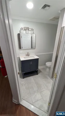 a bathroom with a sink a toilet and mirror
