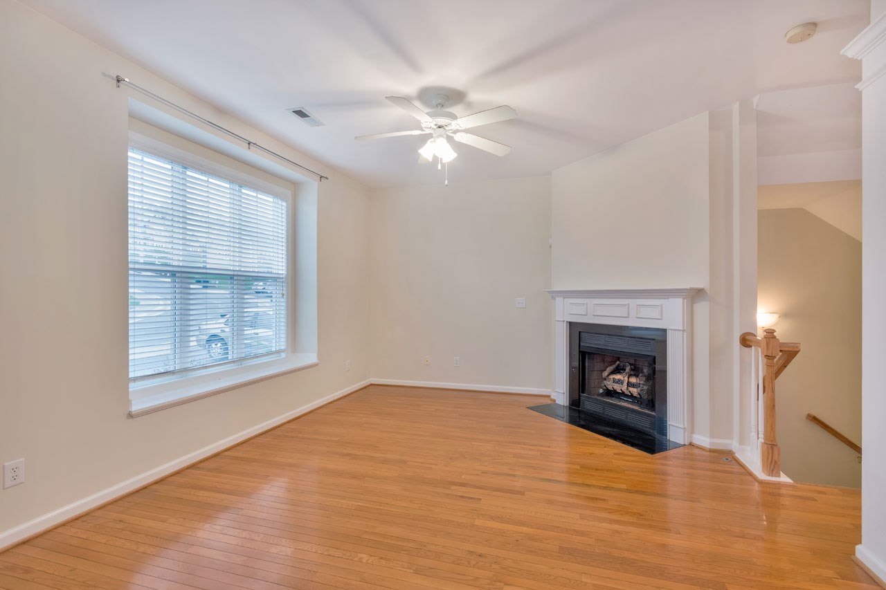 1319 Stoney Ridge Road Charlottesville, VA 22902 - Photo 4 of 17 a view of empty room with wooden floor fireplace and a window