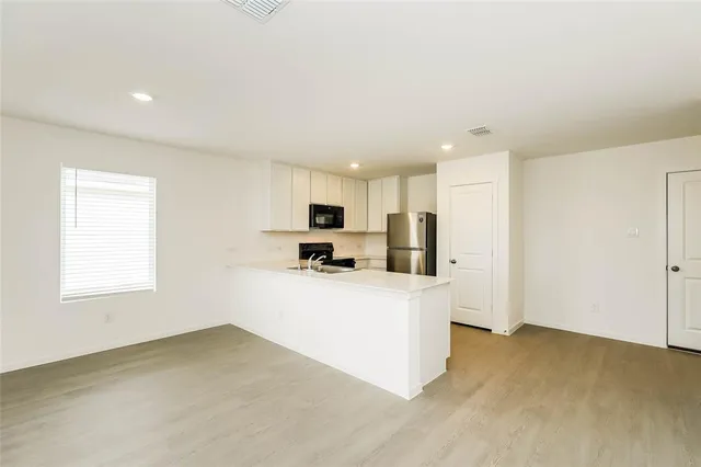 a view of kitchen with wooden floor and electronic appliances