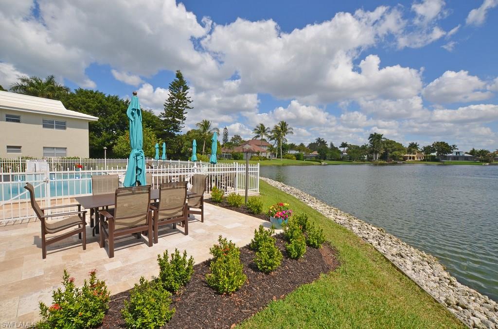 a view of a lake with table and chairs